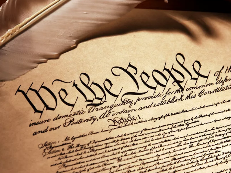 The top of the US Constitution beginning with We The People