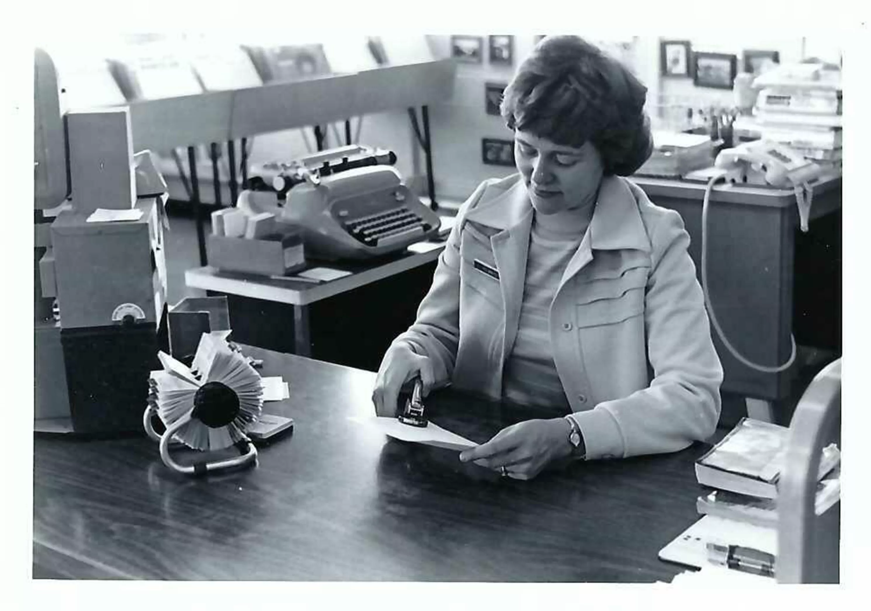 black and white image of library staff stamping library card