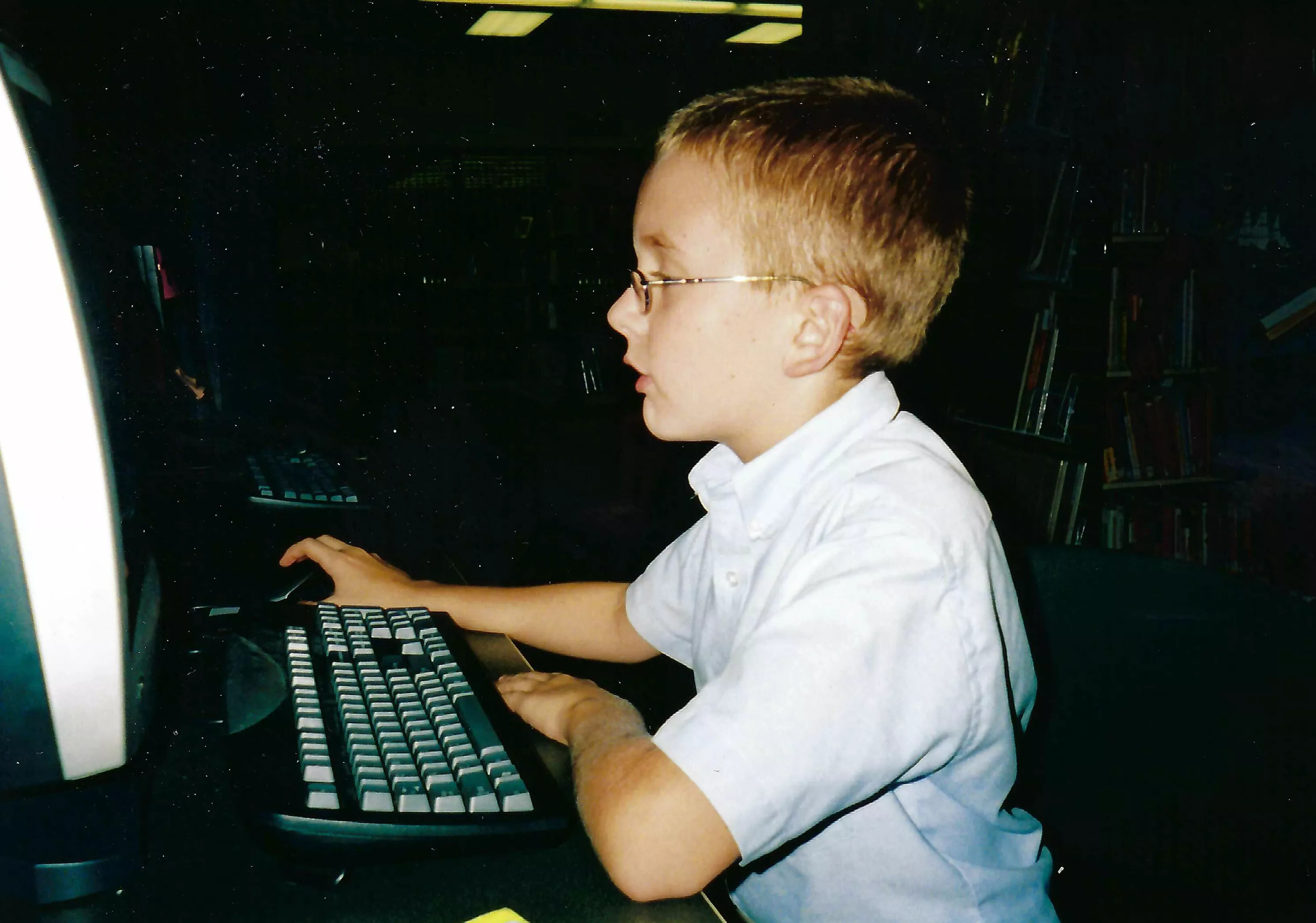 Image of child sitting at a computer in the 90s