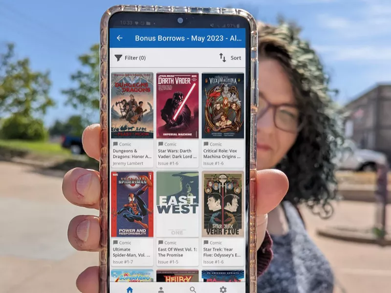 colored photo of woman holding her phone towards the camera with eBooks on display